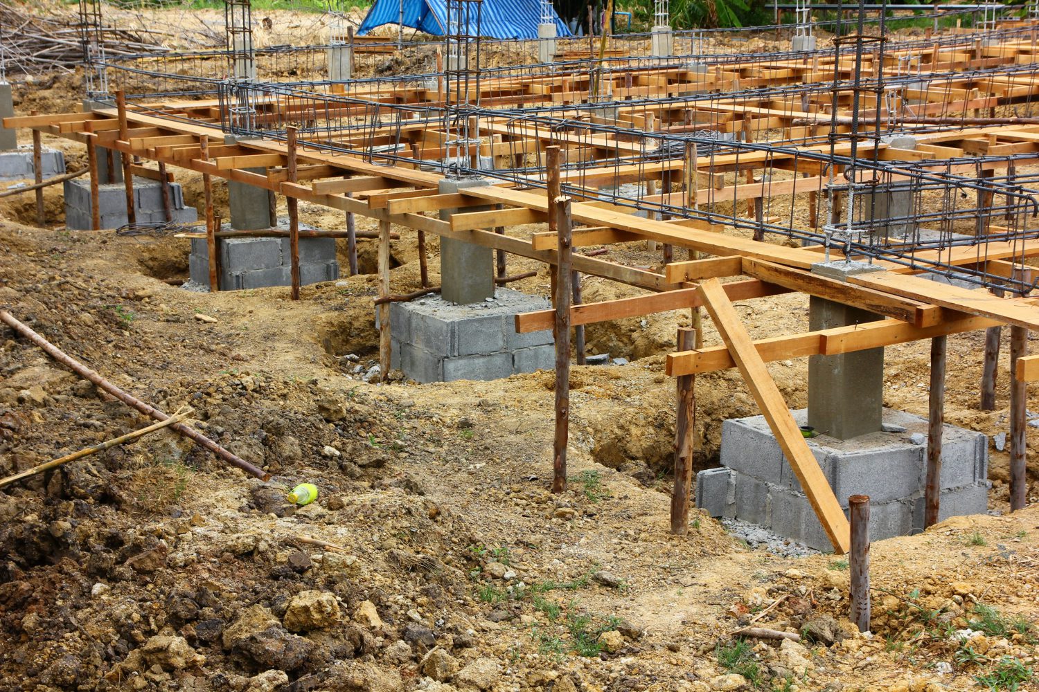 "Concrete foundation and rebar framework during the early stage of residential construction"