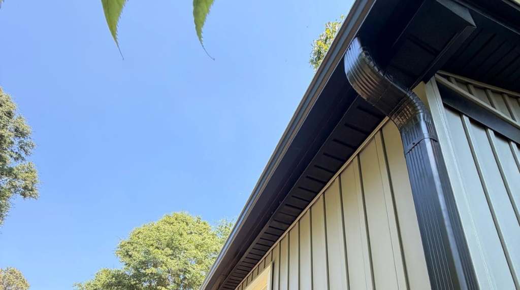 Black seamless gutter system installed on residential home exterior in South Central Tennessee