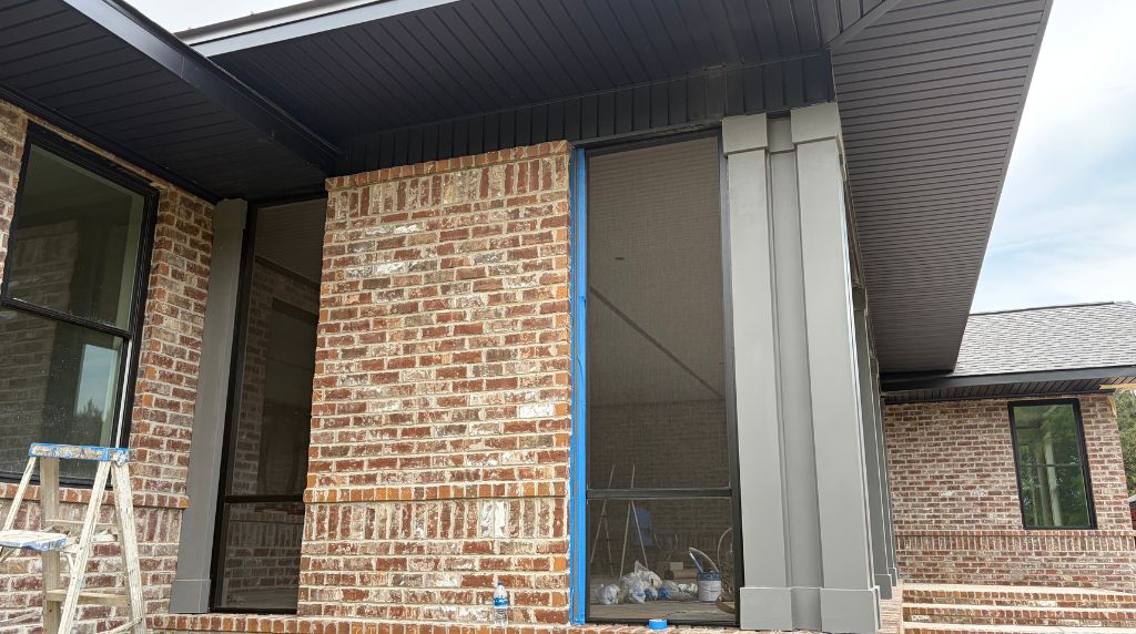 Aluminum screen room addition attached to a brick home with durable screened enclosure panels