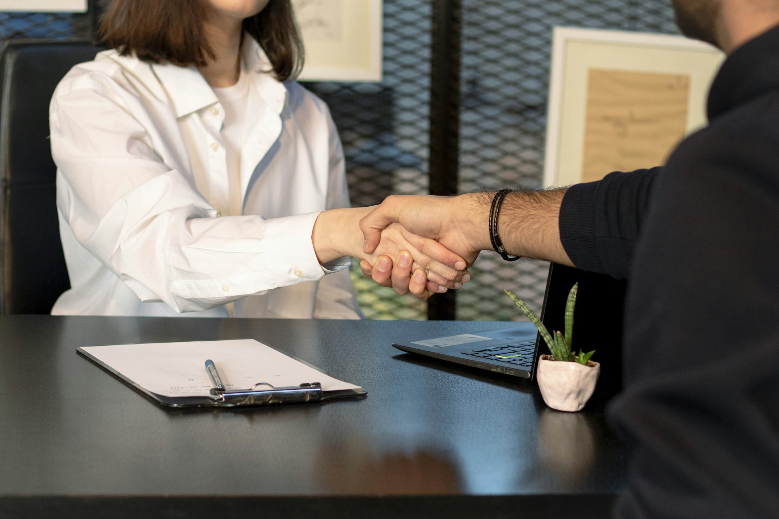 Home warranty companies image showing a contract handshake close-up.