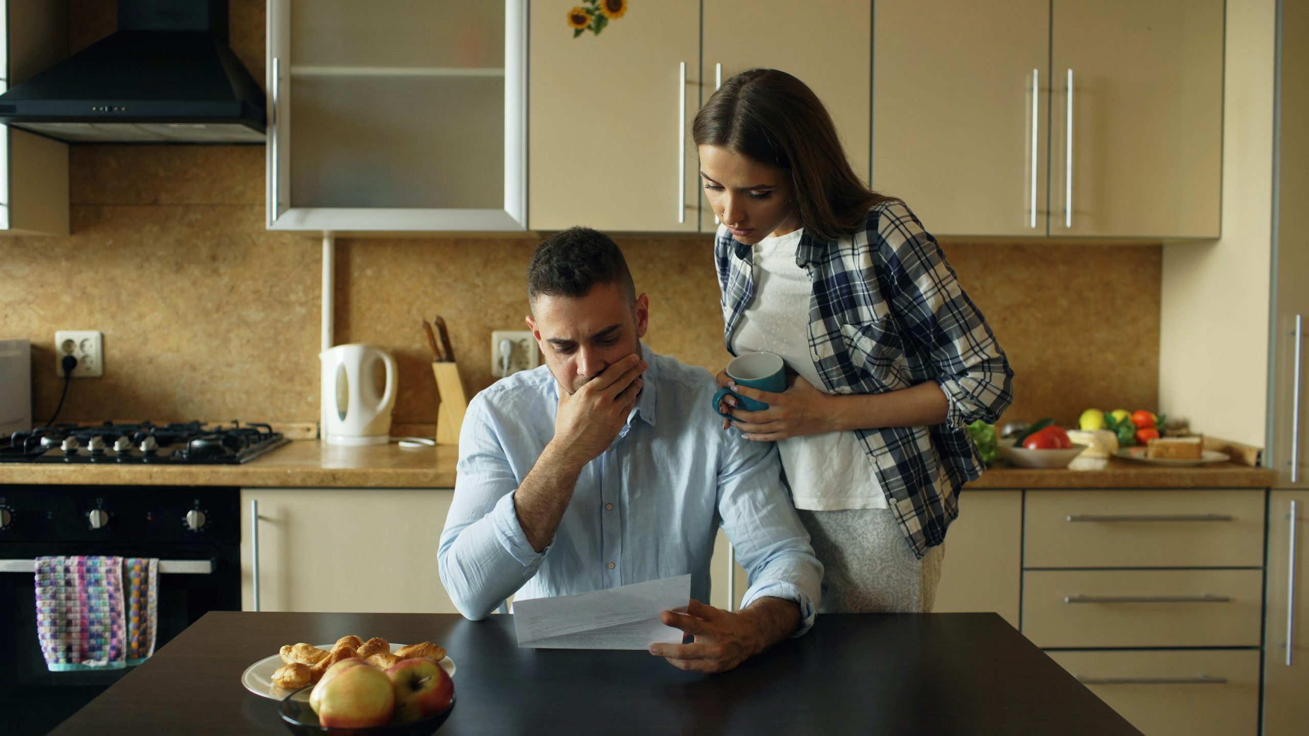 Home warranty cost image of people reviewing household bills at a kitchen table.